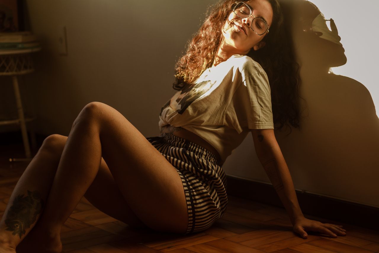 Home A serene woman enjoying sunlight indoors, reflecting a peaceful mood.