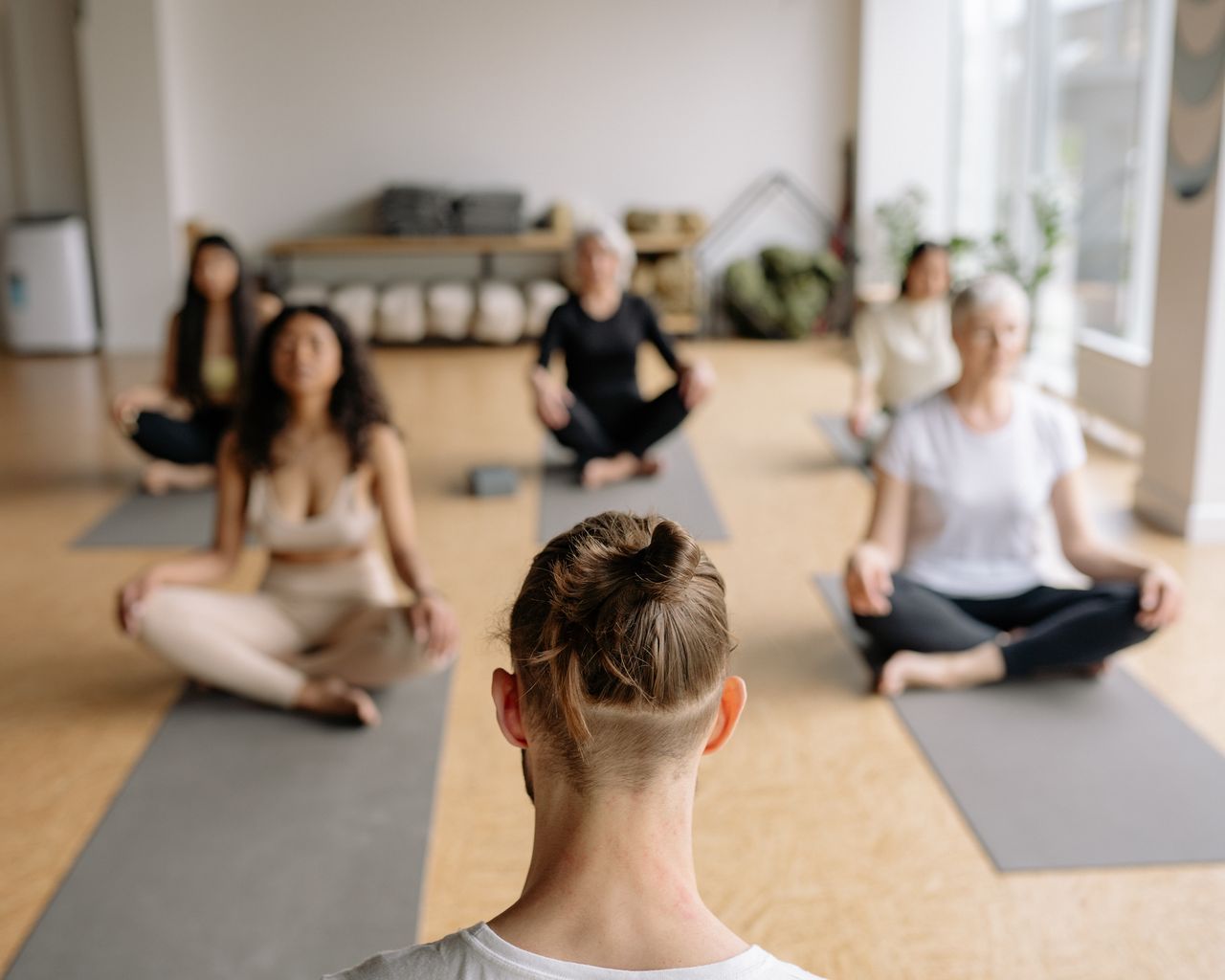 gallery-04 A group of diverse adults practicing yoga indoors, promoting mindfulness and relaxation.